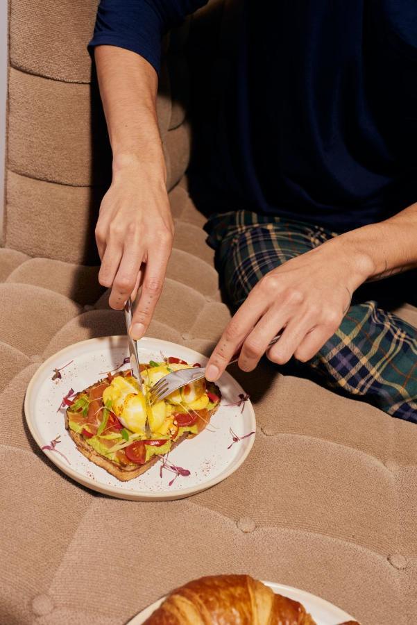 Sanderson London Ngoại thất bức ảnh A person using a knife and fork to cut food